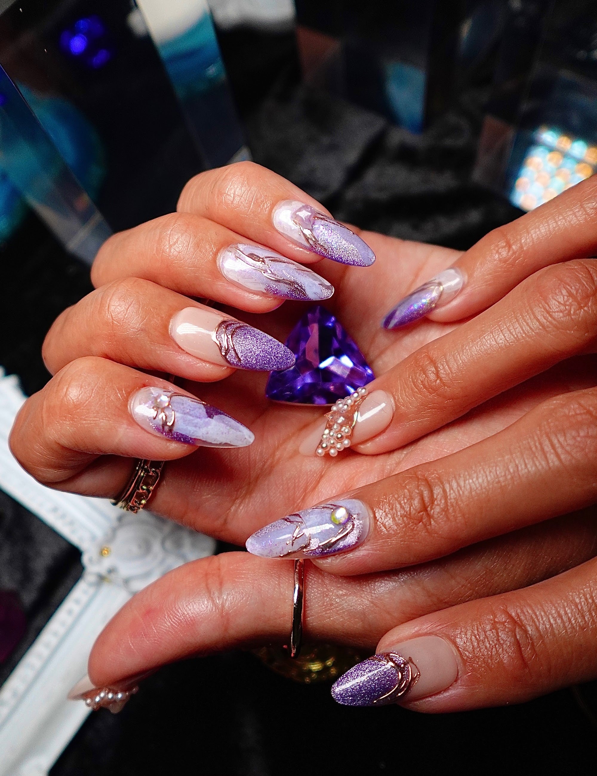 Hands holding a cut amethyst, wearing Amethyst lilac marble press-on nails from Crystal Muse