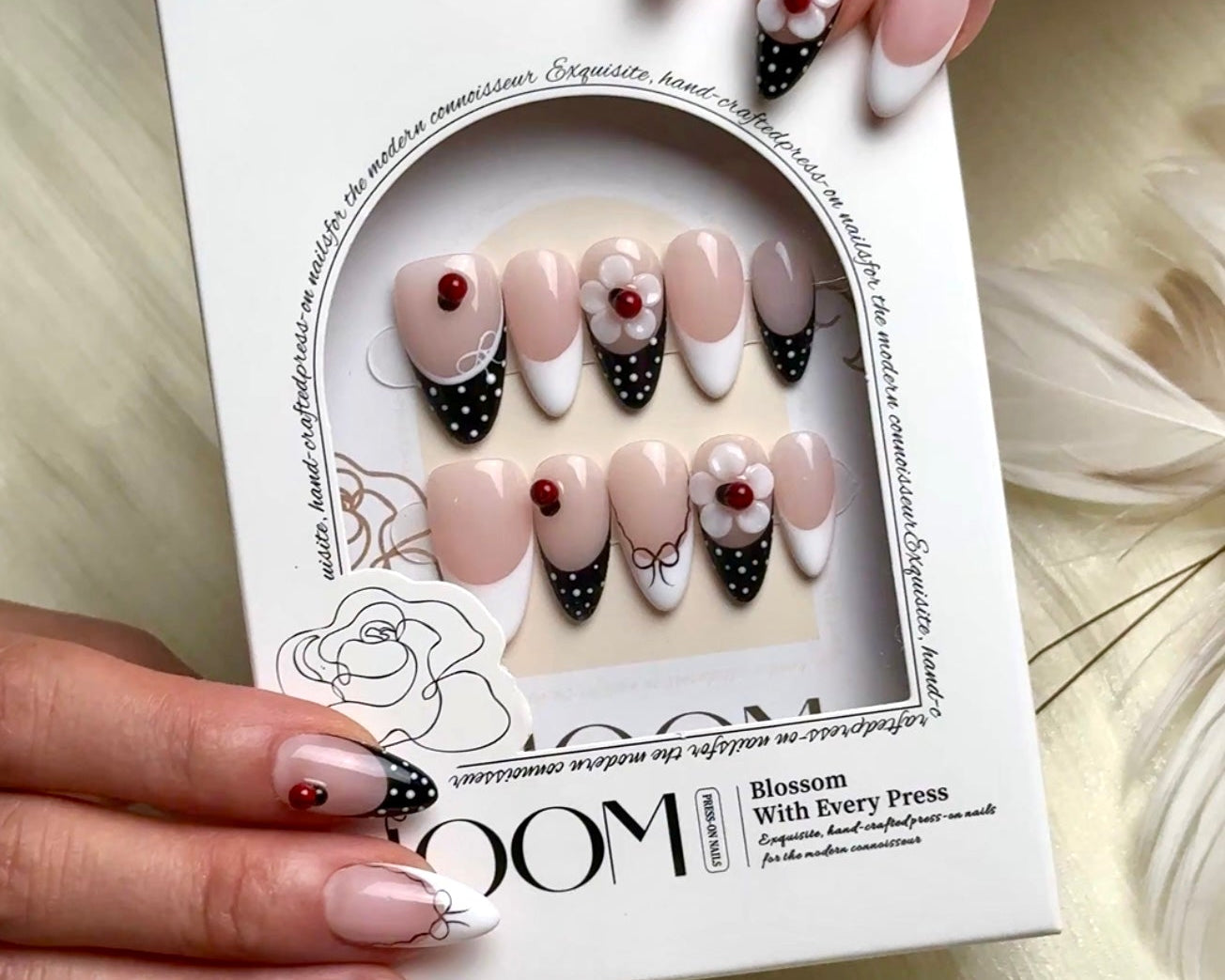 Lovie Bug medium almond press-on nails by Bloom Nails, worn and shown in the box with all ten sizes