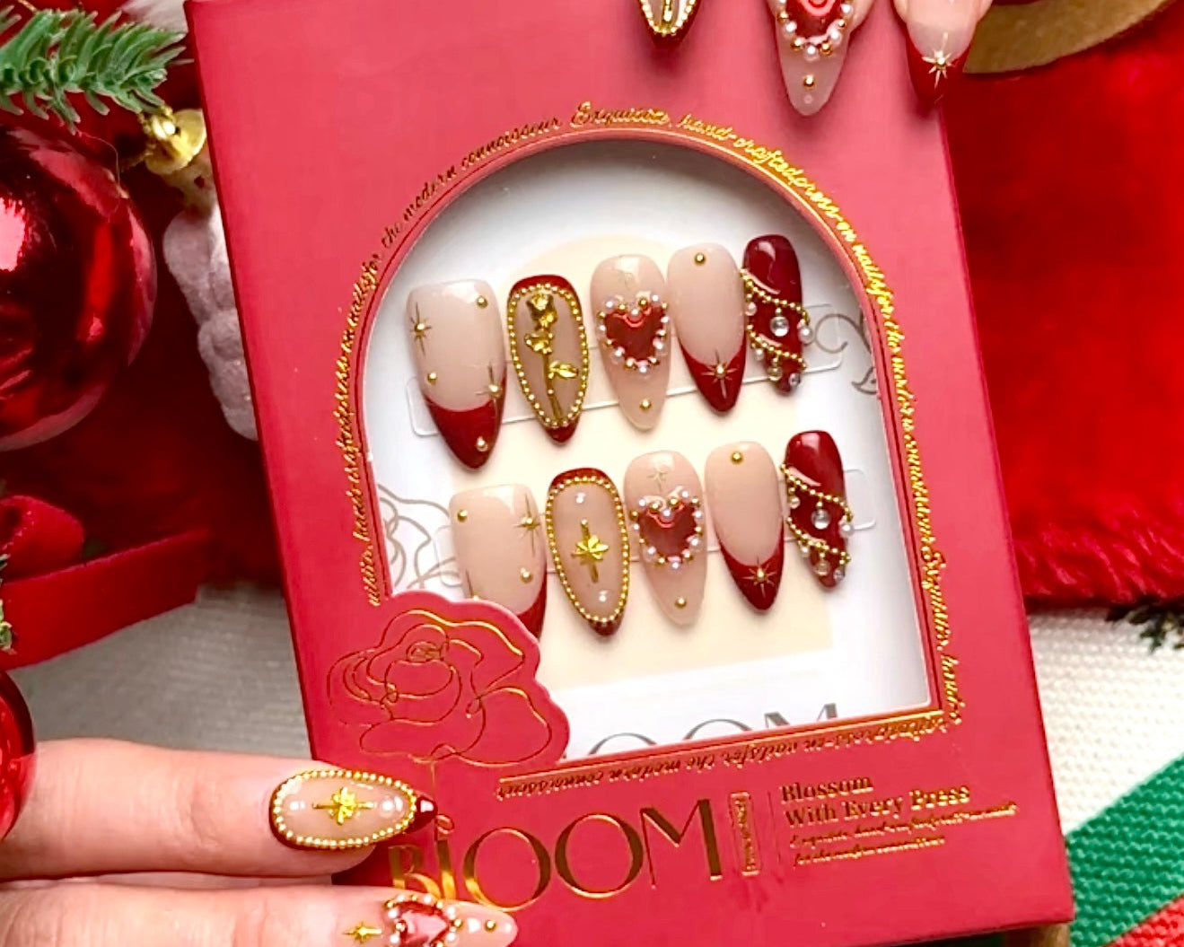 Golden Amour holiday press-on nails by Bloom Nails in a red gift box with holiday decor